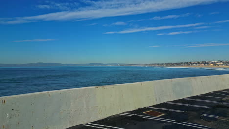 aerial drone over king harbor car park wall with views across the pacific ocean at manhattan beach in california