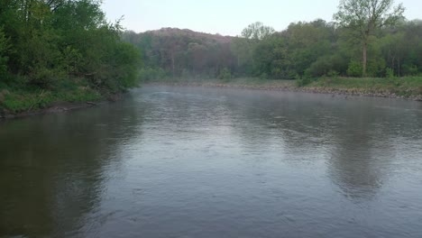 río brumoso con puente y bosque