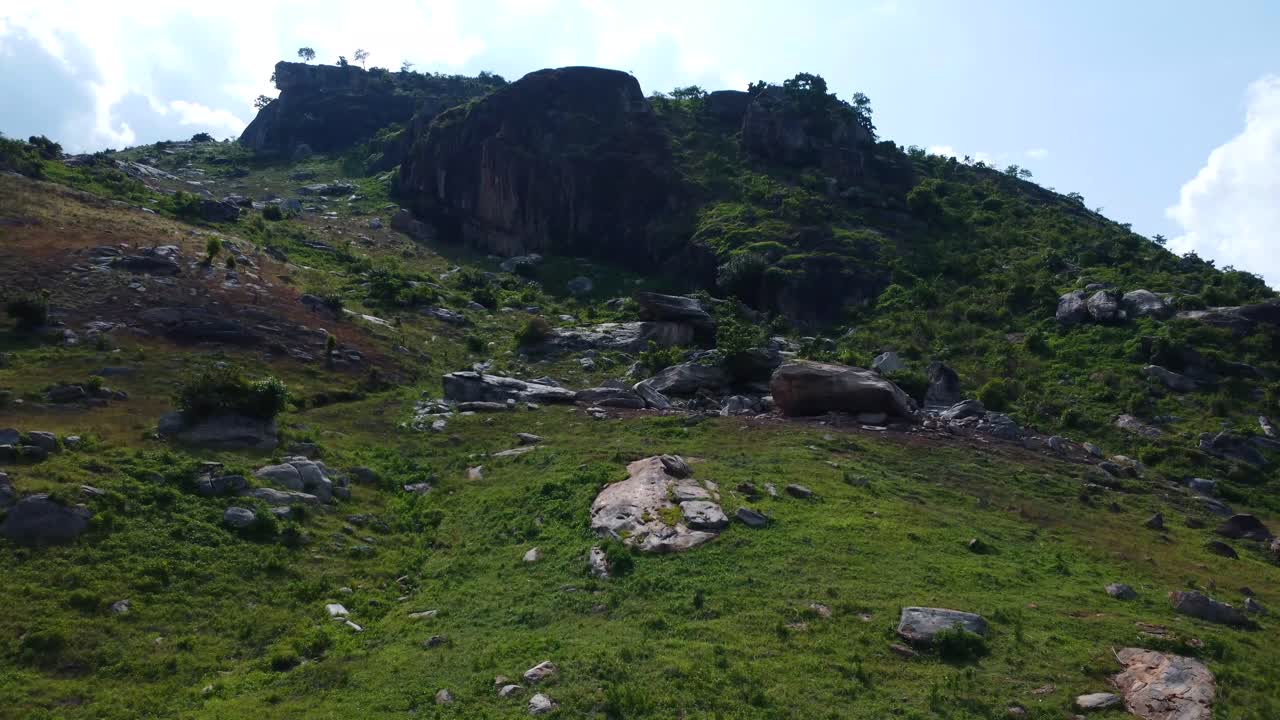 Drone of rocky slope with sparse vegetation and wide terrain near Abuja’s countryside, Nigeria