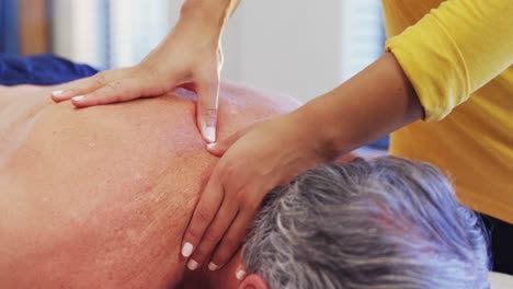 fisioterapeuta dando masaje de hombro a un hombre mayor 4k