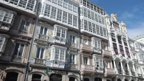 elegant facade of historical buildings with intricate balconies and glass windows under blue sky