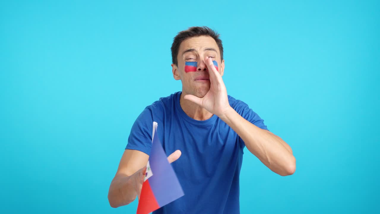 Man cheering for Haiti during a match that is lost