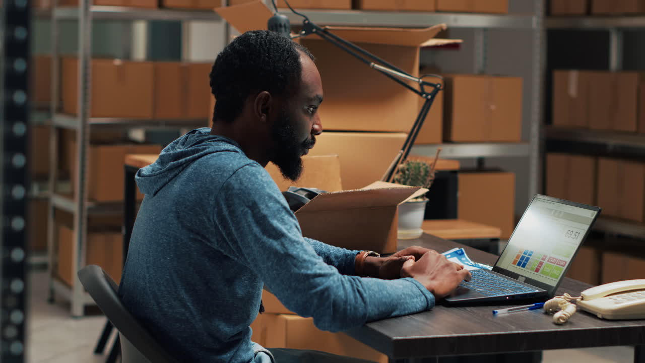 Man working on laptop in warehouse