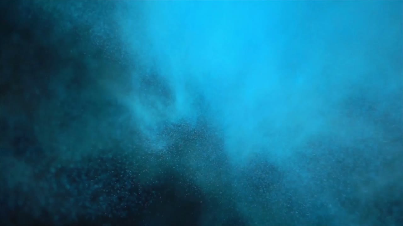 Blåt pulver, der brister i slowmotion på sort baggrund