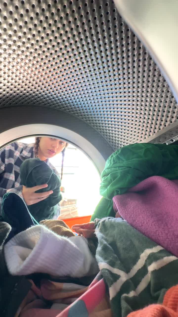 Person Loading Clothes into Washing Machine