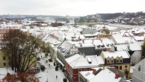 Revelando-Tejados-Cubiertos-De-Nieve-Del-Casco-Antiguo-De-Kaunas,-Vista-Aérea-Ascendente