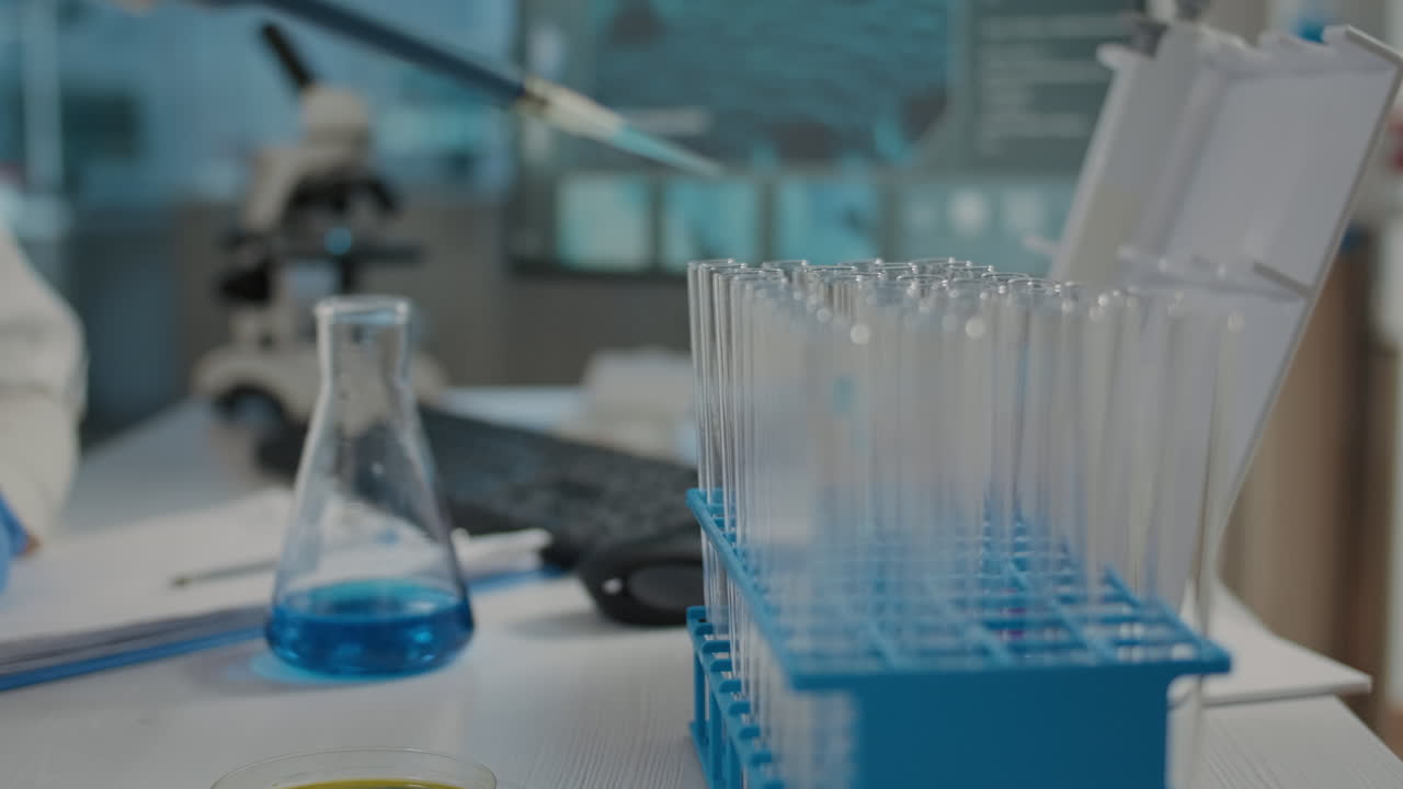 Chemical engineer using micro pipette to put solution in beaker