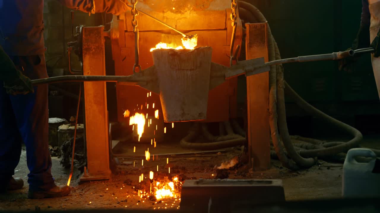 Male worker mixing molted metal in container at workshop 4k