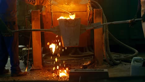 trabajador masculino mezclando metal moldeado en un contenedor en el taller 4k