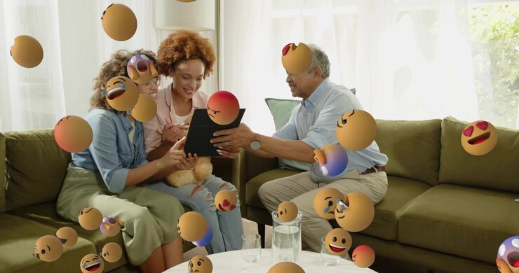 Family smiling examining tech tablet as emoji icons emerging, man taking tablet, women laughing