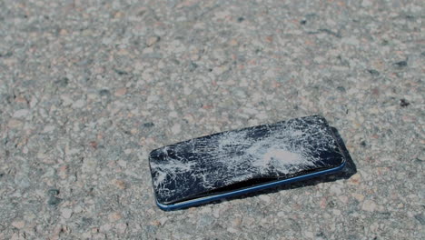 close up view of smartphone being run over and crushed by vehicle