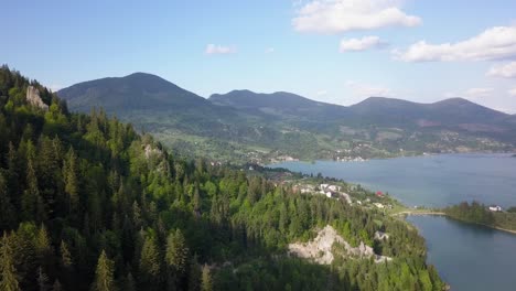 aerial panning shot of lake with mountain range in the background