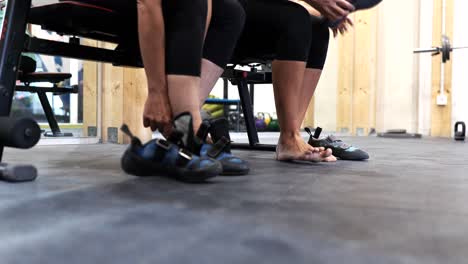 mujeres deportistas de cultivos abrochando zapatos de escalada