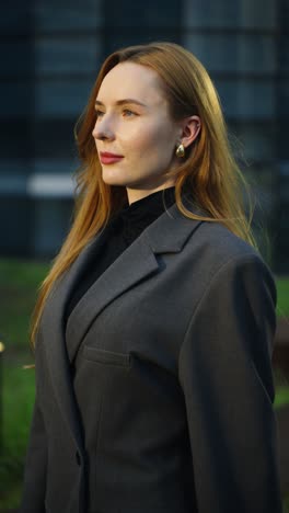 a caucasian, thoughtful professional woman looks at the sunset over the seoul cityscape from the office building rooftop, cinematic dolly-in shot