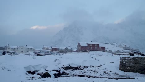 static shot of snow-covered mountains and houses in a wintry landscape