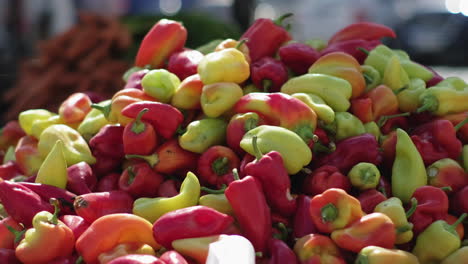 una pila de pimientos de color en un mercado de agricultores