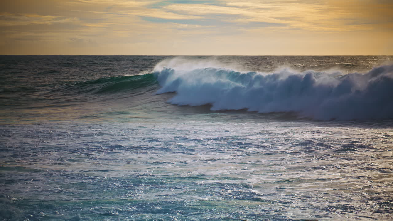 las poderosas olas del océano rodando la orilla del mar en una mañana soleada. movimiento lento olas enormes