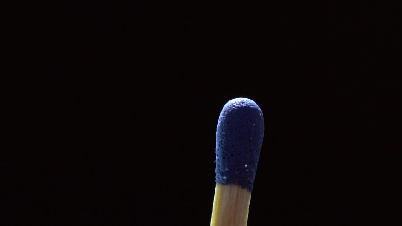 Close-up of a Blue Matchstick Head Isolated on a Black Background