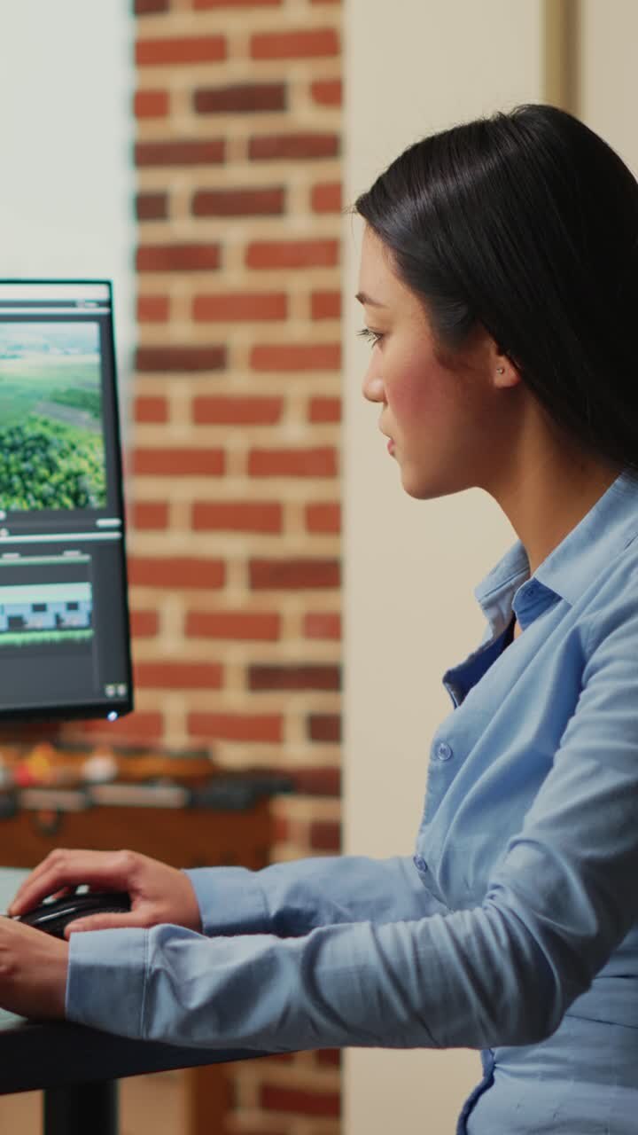Vertical video: Asian filmmaker editing video and audio footage on multi monitors