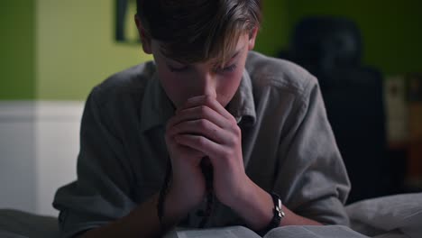 boy praying by his bed