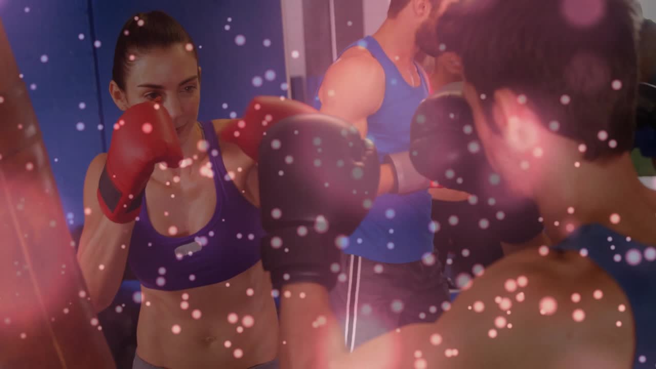 Boxer throwing combos as partner holding mitts triggers drill in boxing class, pink bokeh overlay