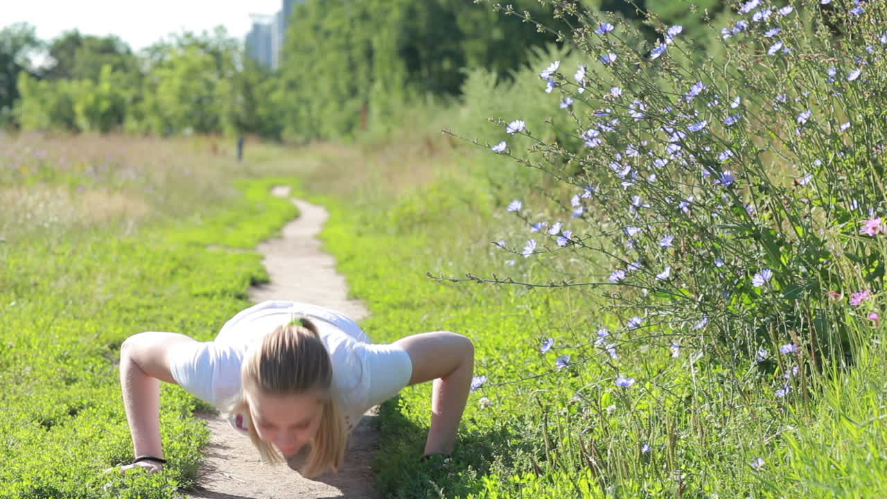 공원에서 푸시 업을 하는 젊은 여성