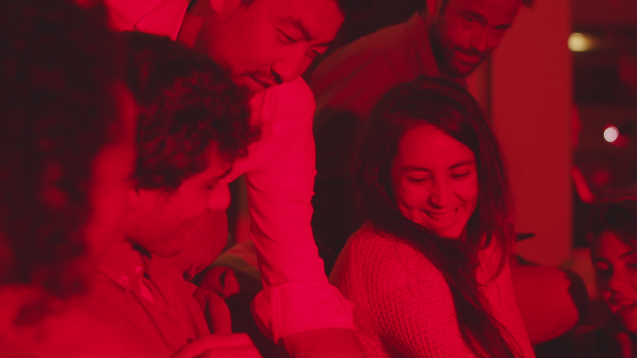 친구 들 의 그룹 이 전화 스크린 을 보고, 집 파티 에서 대화 하고 있다