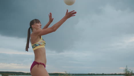 Mujer-Atlética-Vestida-Con-Bikini-Deportivo-Está-Jugando-Voleibol-De-Playa-Retrato-Medio-En-La-Naturaleza-Golpeando-La-Pelota