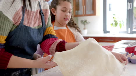 Feliz-Madre-E-Hija-Birracial-Cuidando-La-Masa-En-La-Soleada-Cocina