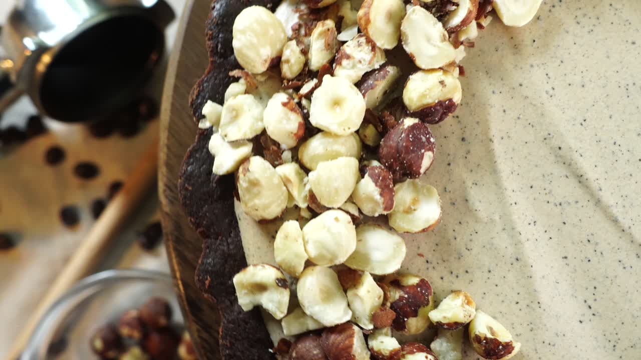 A delicious dessert, Coffee Hazelnut Cream Tart. Made with espresso powder, chocolate crust and loaded with crushed hazelnuts. Great with coffee. Pie or cake going around as a close up