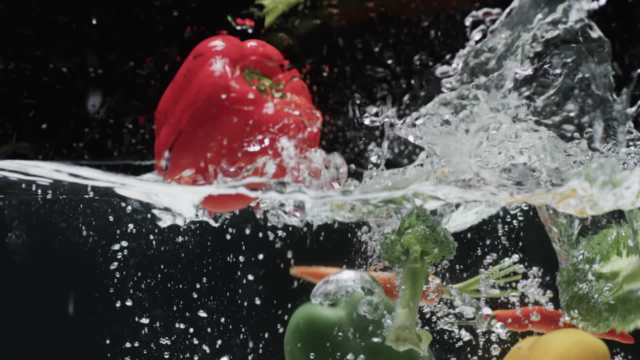 video de verduras cayendo en el agua con espacio de copia en fondo negro