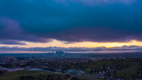 Hiperlapso-De-Drones-Durante-La-Puesta-De-Sol-Sobre-Un-Suburbio-De-Los-ángeles-Con-La-Silueta-Del-Horizonte-Del-Centro-En-La-Distancia