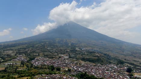 small village and massive mountain of sumbing in indonesia, aerial drone view