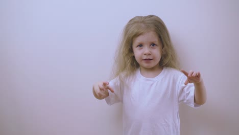 pretty girl in t-shirt tries to scare at white wall in room