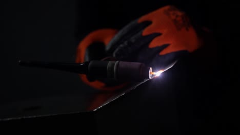 a welder welds a piece of chromium metal using argon gas welding