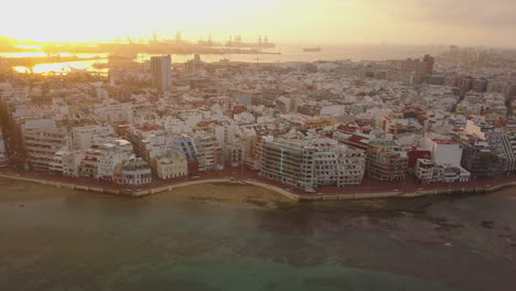 Fantastische-Luftaufnahme-Bei-Sonnenaufgang,-Die-Den-Wunderschönen-Strand-Von-Las-Canteras-Und-Die-Gebäude-In-Der-Umgebung-Zeigt