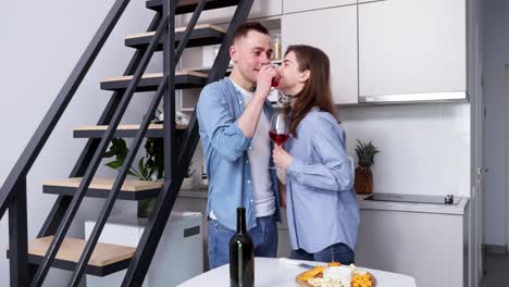 pareja celebrando con vino y queso en la cocina