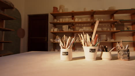 brushes and pottery tools on desk in pottery studio