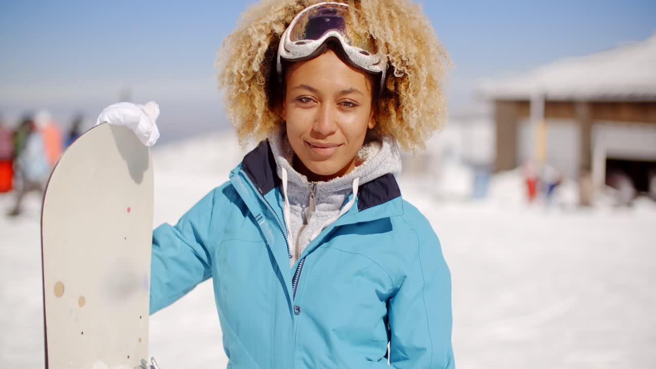Splendida giovane donna alla moda con il suo snowboard.