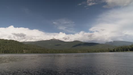 a scenic view of a north idaho lake near the border of canada with clouds forming over the mountains