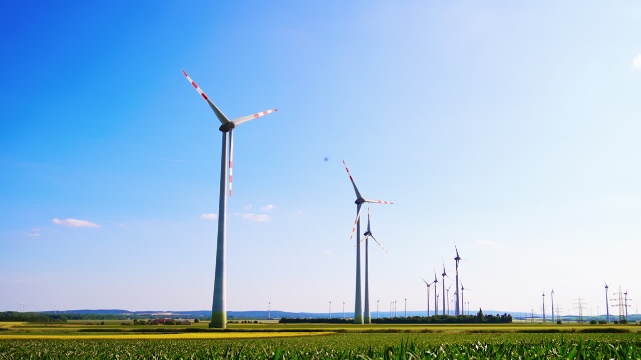 Wind turbines for clean energy. Vast landscape with wind turbines spinning under a clear blue sky at a renewable energy farm in the countryside