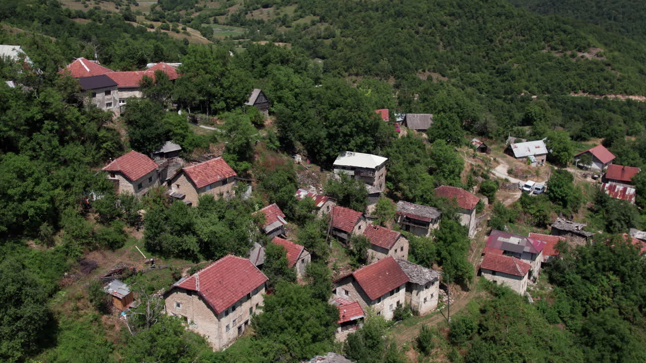 Aerial View of a Rural Village with Red Roofs and Green Trees