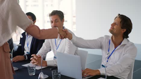 delegados de negocios estrechando la mano en una conferencia