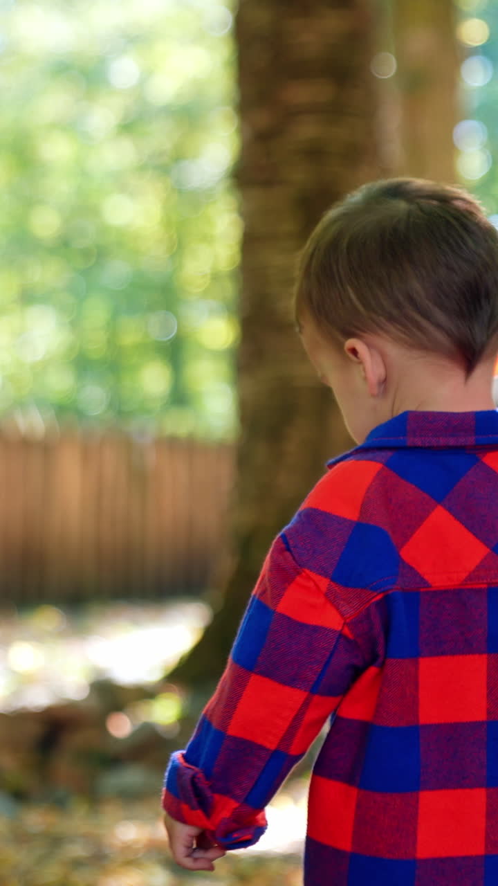 Small stylish boy outdoor walking. Striped cloth wearing kid playing. Vertical video