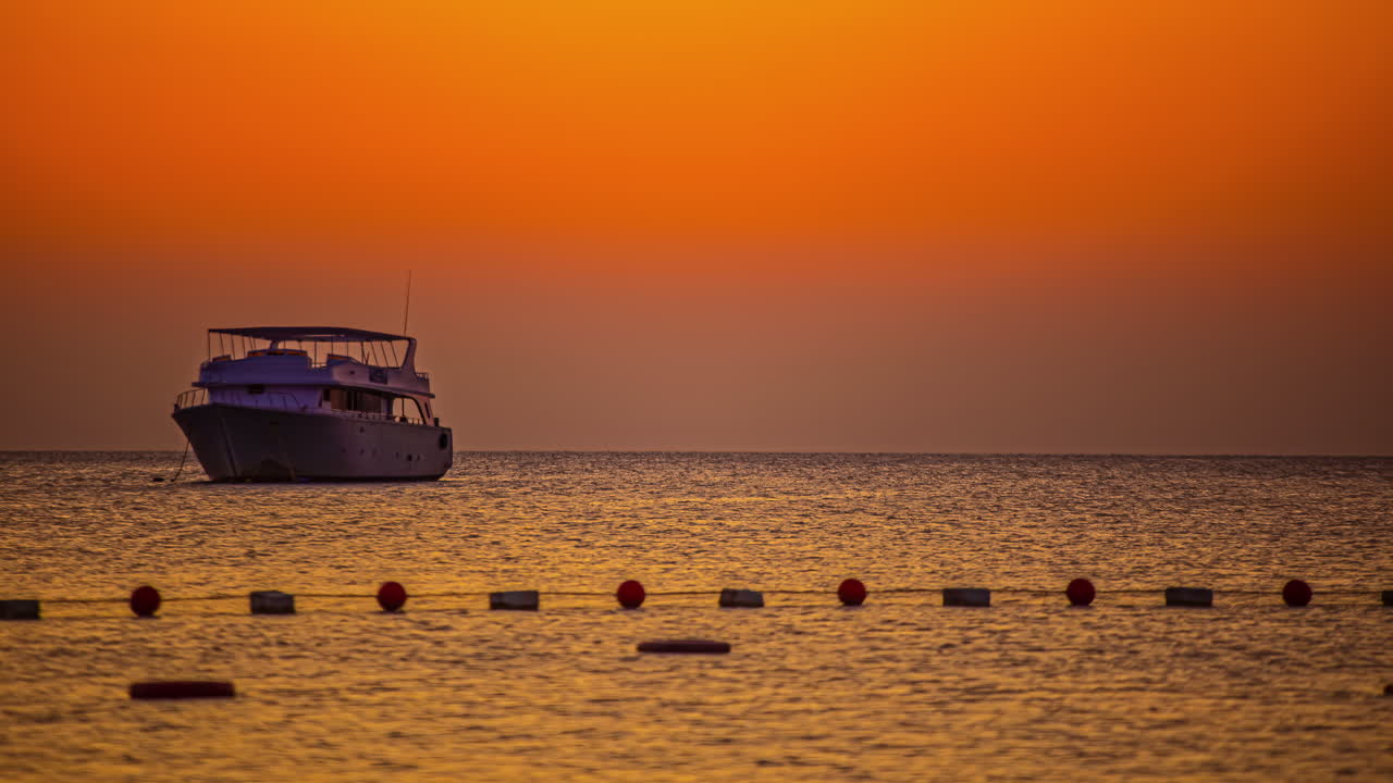 barco anclado en el mar rojo al amanecer - lapso de tiempo del amanecer dorado