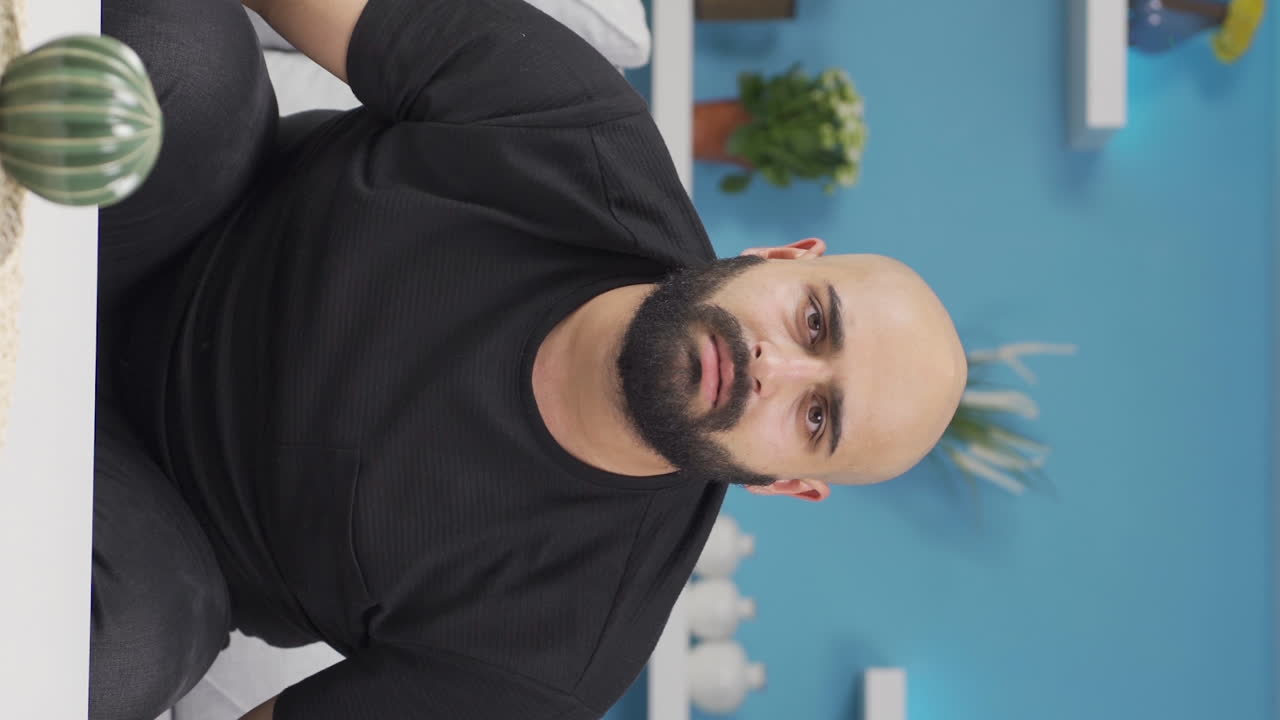 Vertical video of Man looking at camera confused.