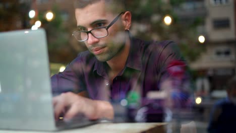 Hispanic-businessman-using-laptop-in-cafeteria