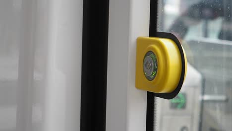 yellow button on a public transportation door