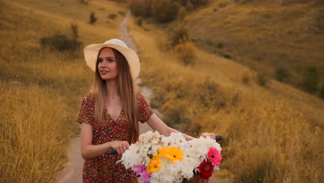 Mädchen-Im-Mittleren-Plan-Im-Kleid-Geht-Mit-Fahrrad-Und-Blumen-Auf-Dem-Feld