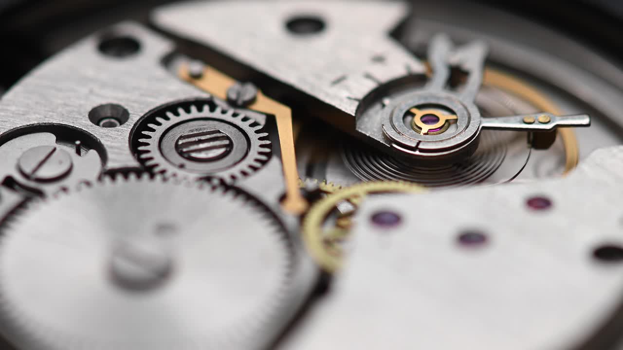 Internal working mechanism of the wristwatch with a rapidly rotating pendulum and gears. 4k clock close up with shallow depth of field